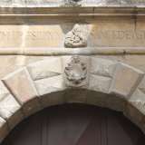 Un altro esempio di bassorilievo che raffigura una Madonna con il bambino. E' posto sull'architrave del portone dell'antico palazzo nobiliare della piazzetta dei 62 marinai
